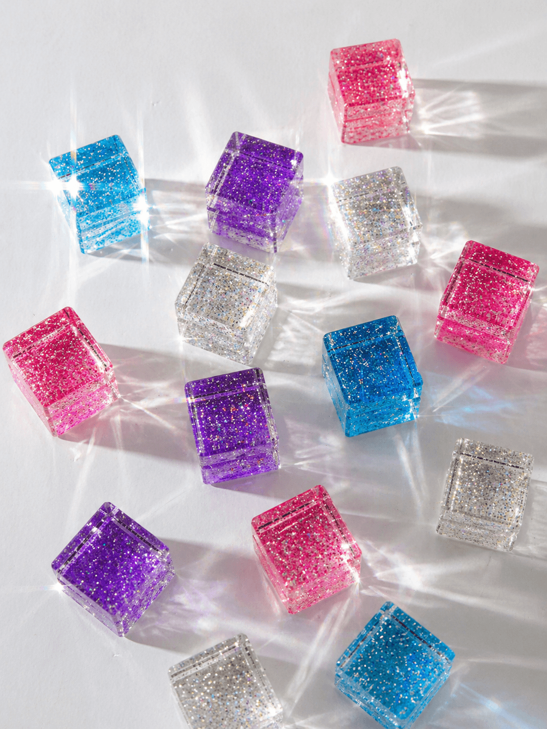 Colorful cosmic cube acrylic glitter blocks creating prismatic light effects.