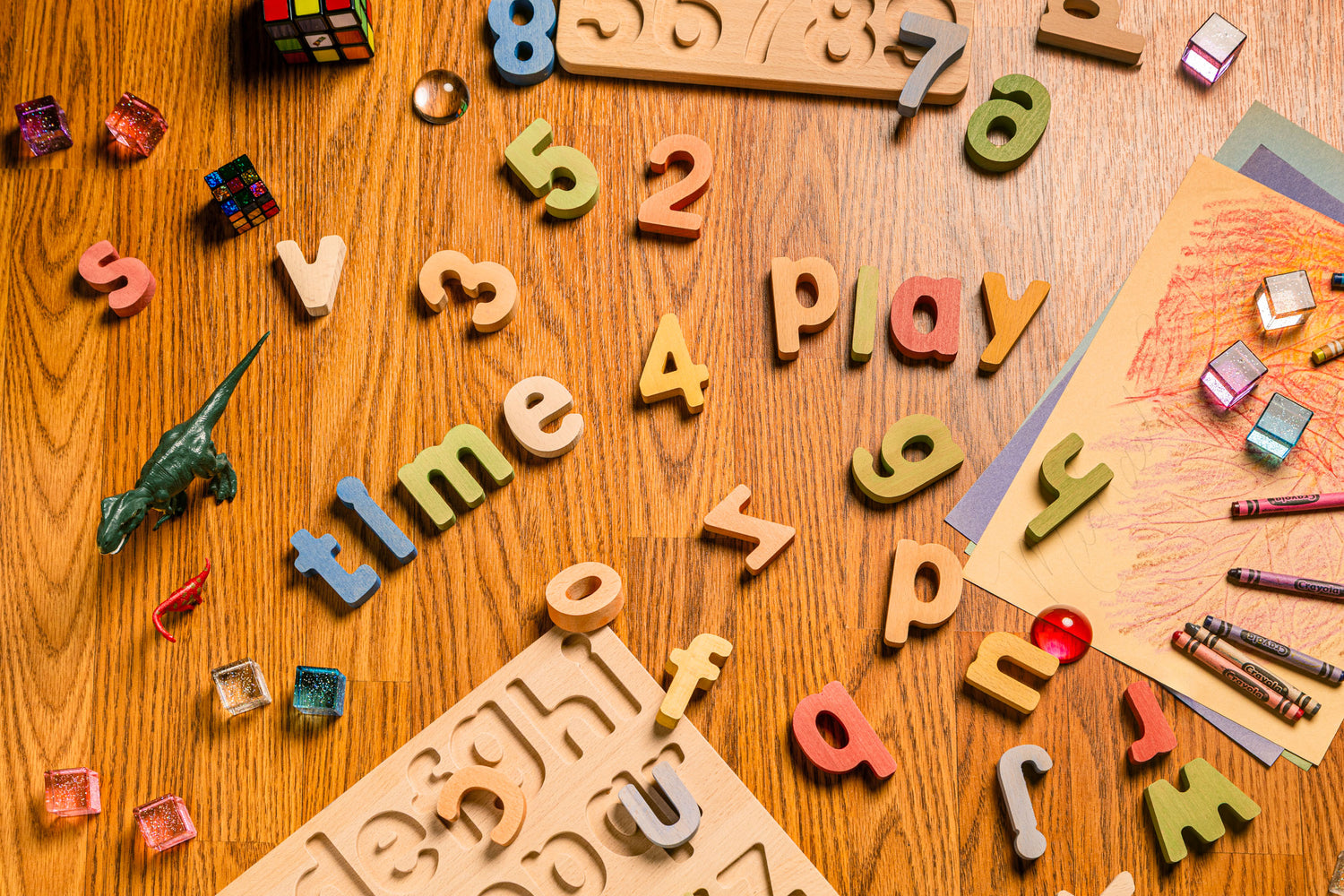 Colorful educational puzzle set pieces scattered on a wooden table, promoting hands-on learning and play.