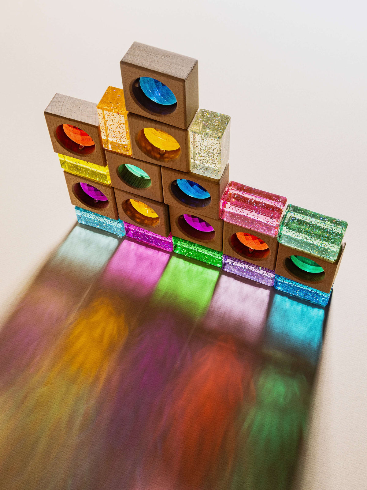 Aura glitter acrylic building blocks stacked beautifully, featuring shimmering colors and natural beechwood elements.