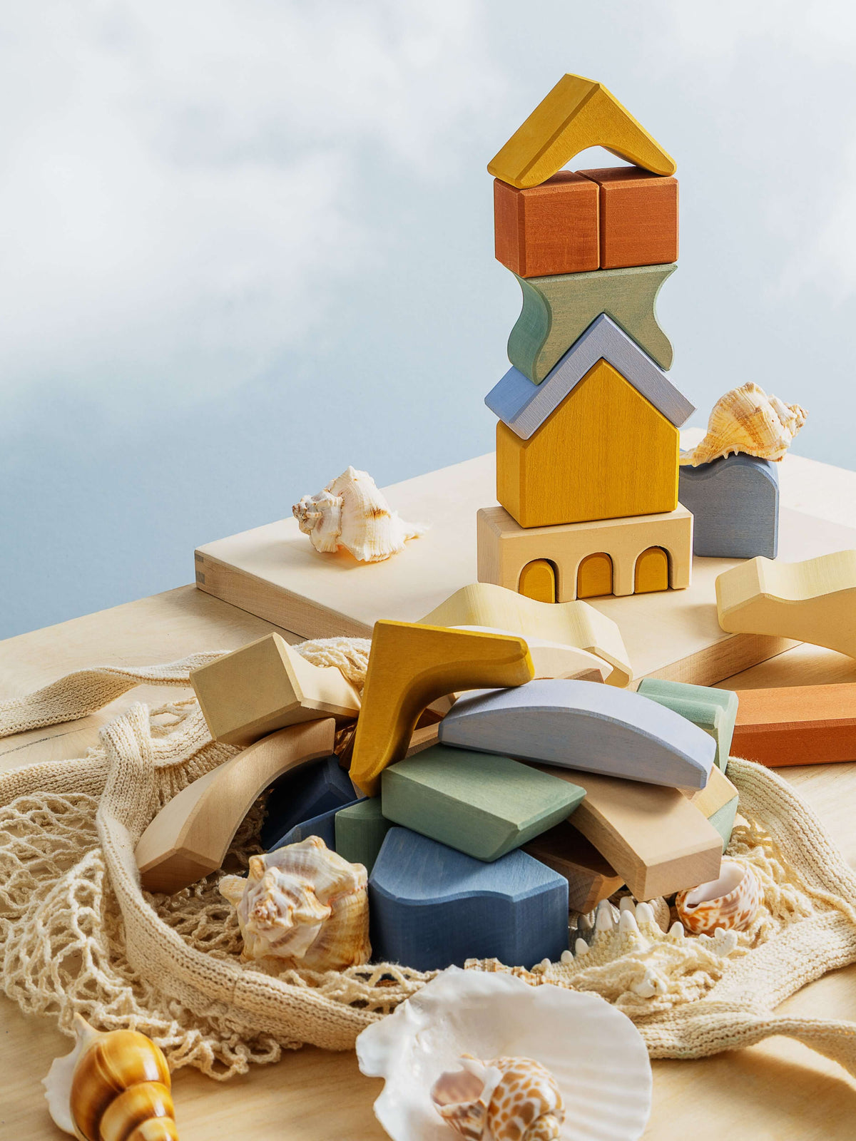 Malibu Puzzle displayed with colorful wooden blocks and seashells on a table, showcasing creativity and playtime.