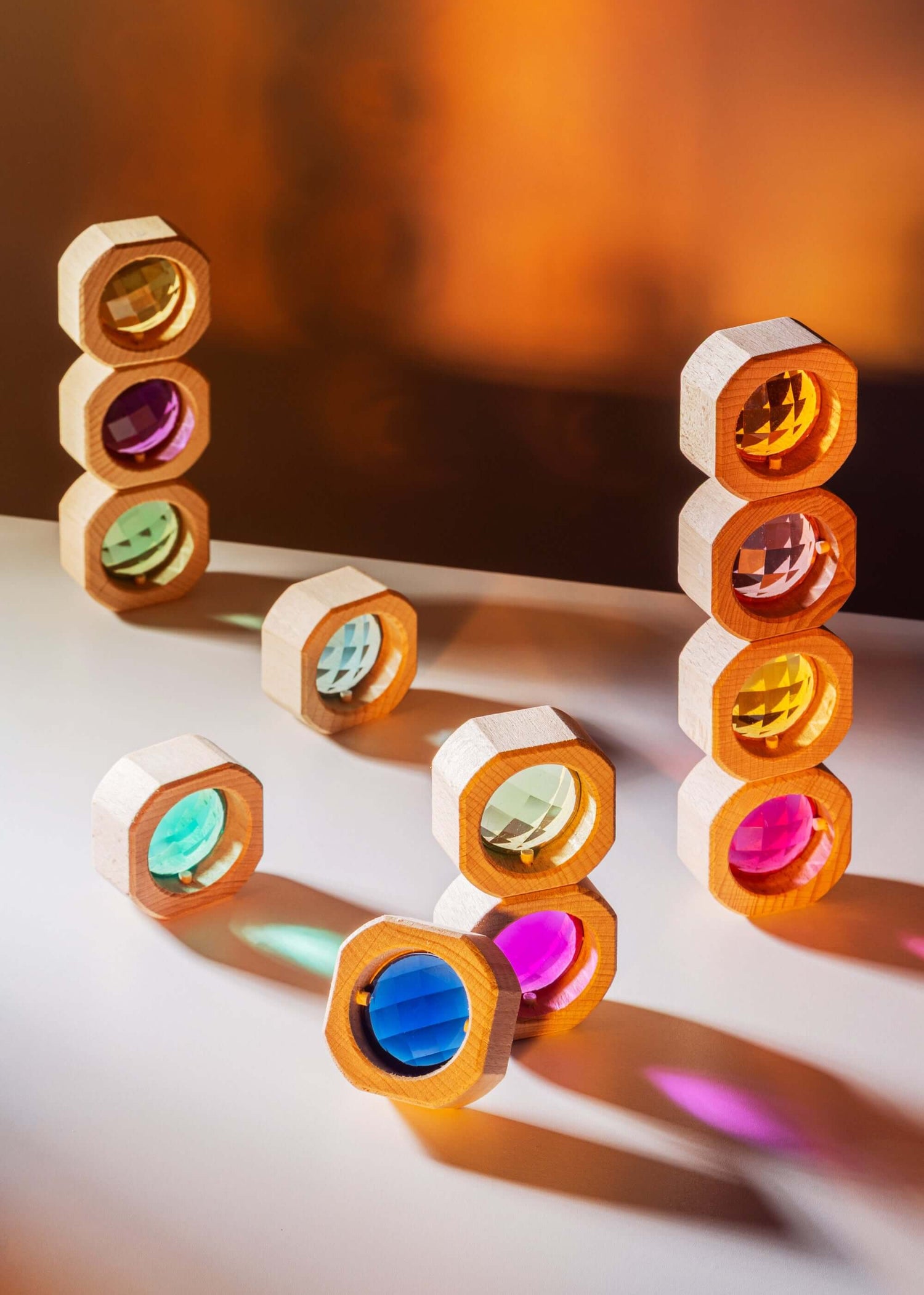 Colorful geometric shapes stacked on a reflective surface with a warm-toned background