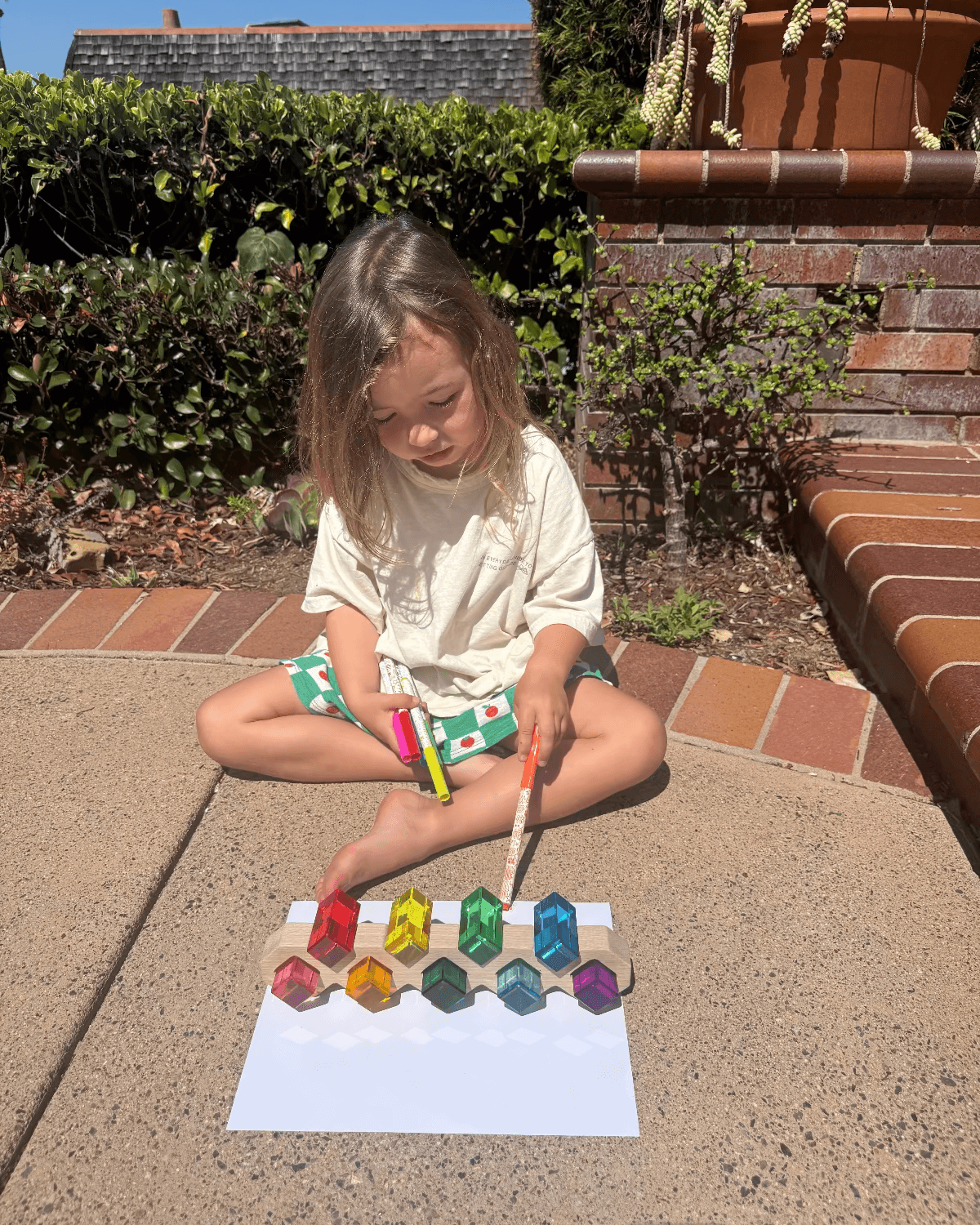 A toddler engaging in screen-free summer activities for toddlers, playing with colorful toys outdoors.