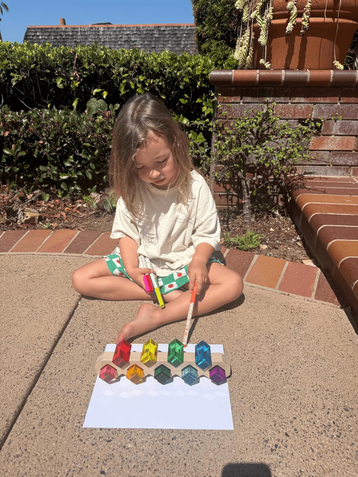 A toddler engaging in screen-free summer activities for toddlers, playing with colorful toys outdoors.
