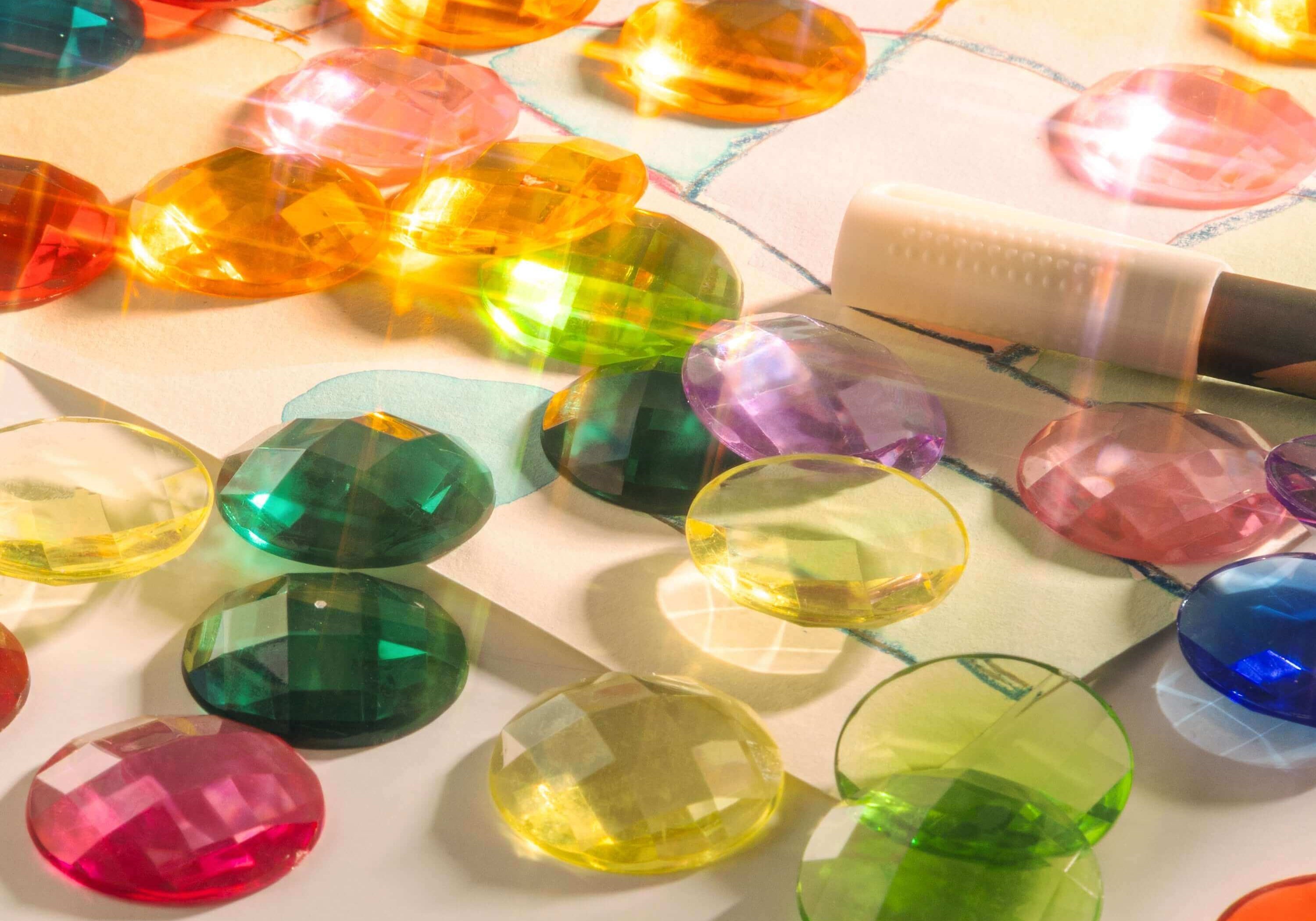 Colorful sensory gems scattered on a surface, showcasing how Sensory Gems Support Early Development.