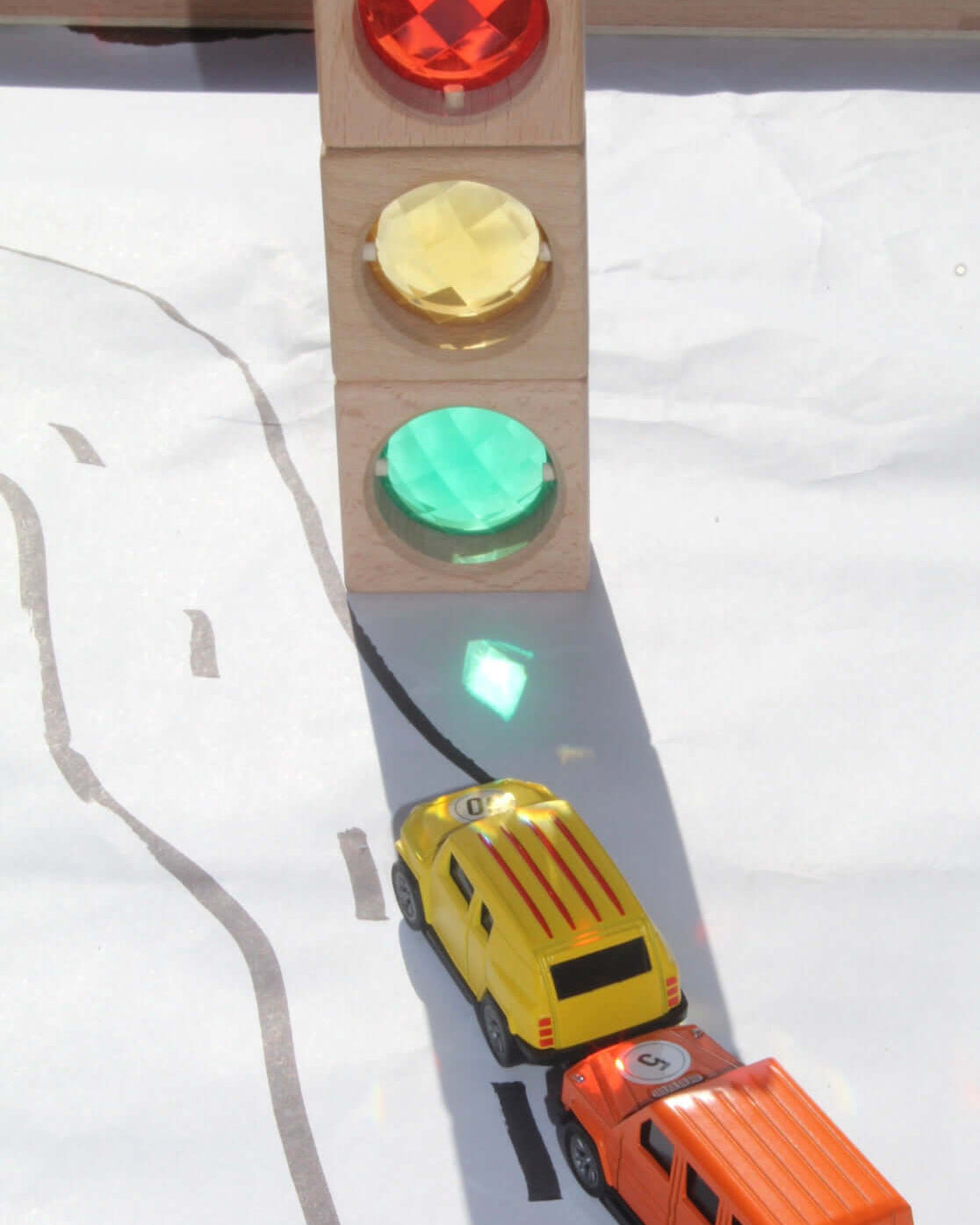 Maison Rue translucent blocks casting colored shadows on toy cars