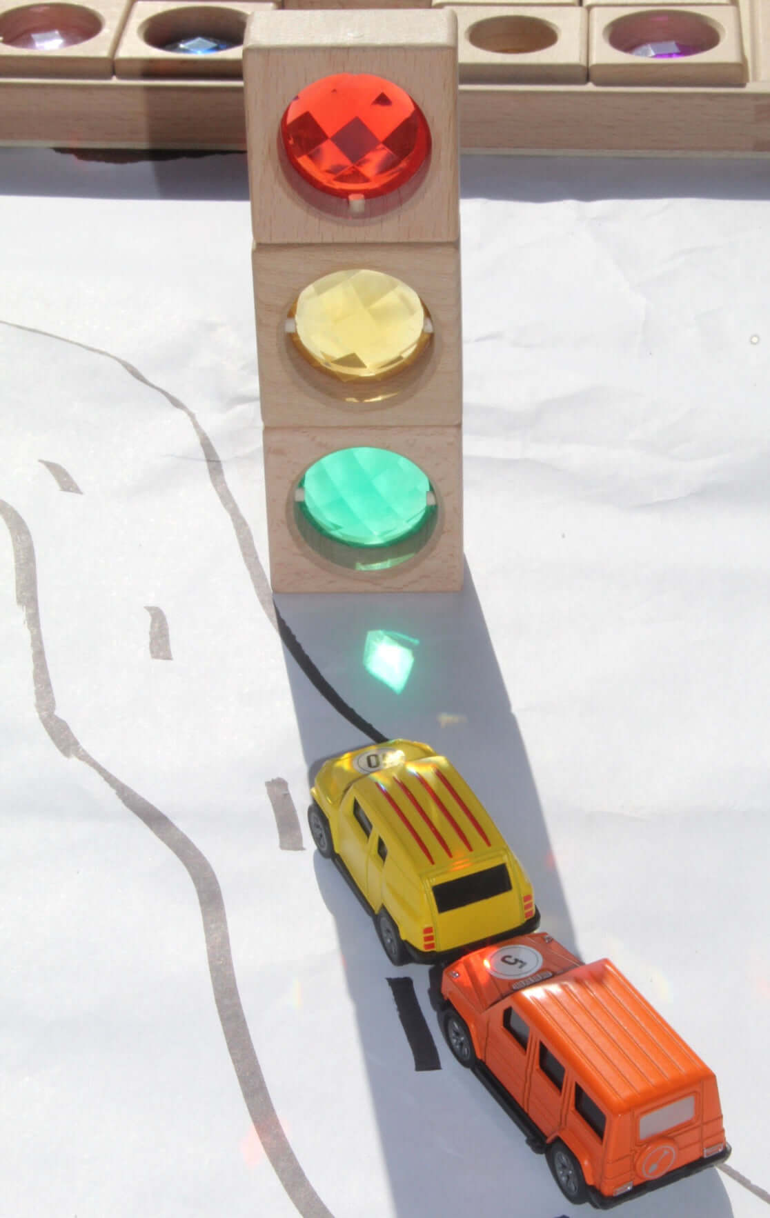 Maison Rue translucent blocks casting colored shadows on toy cars