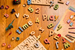 Colorful educational puzzle set pieces scattered on a wooden table, promoting hands-on learning and play.