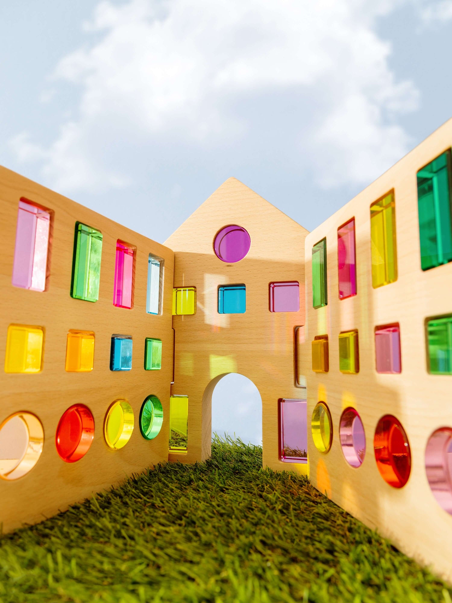 Rêve House Set modular wooden building set creating a colorful architectural structure under a blue sky.