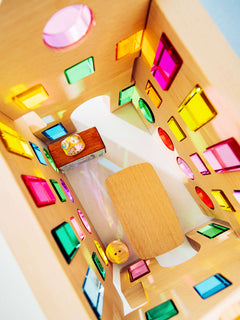 Inside view of Rêve House Set modular wooden building set featuring colorful geometric windows and a small table.