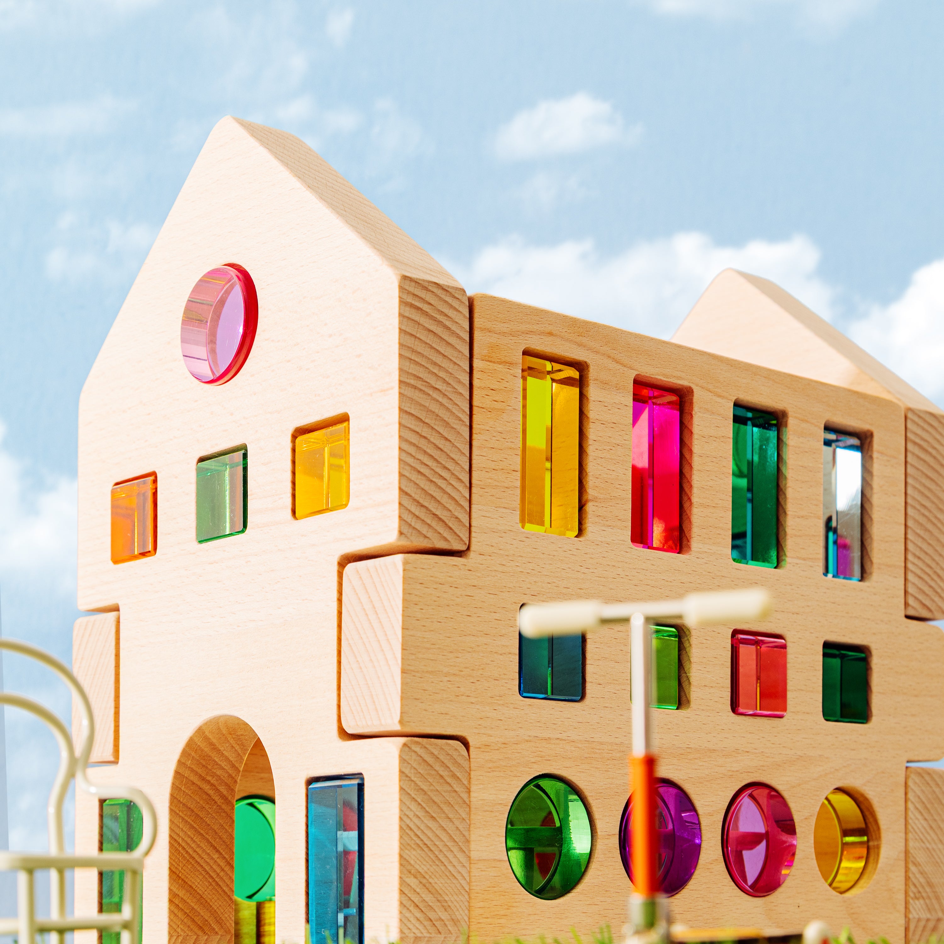 Colorful wooden building from the grand building collection set against a blue sky, promoting imaginative play.