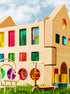 Rêve House Set modular wooden building set with colorful transparent panels, complete with toy scooter and chair.