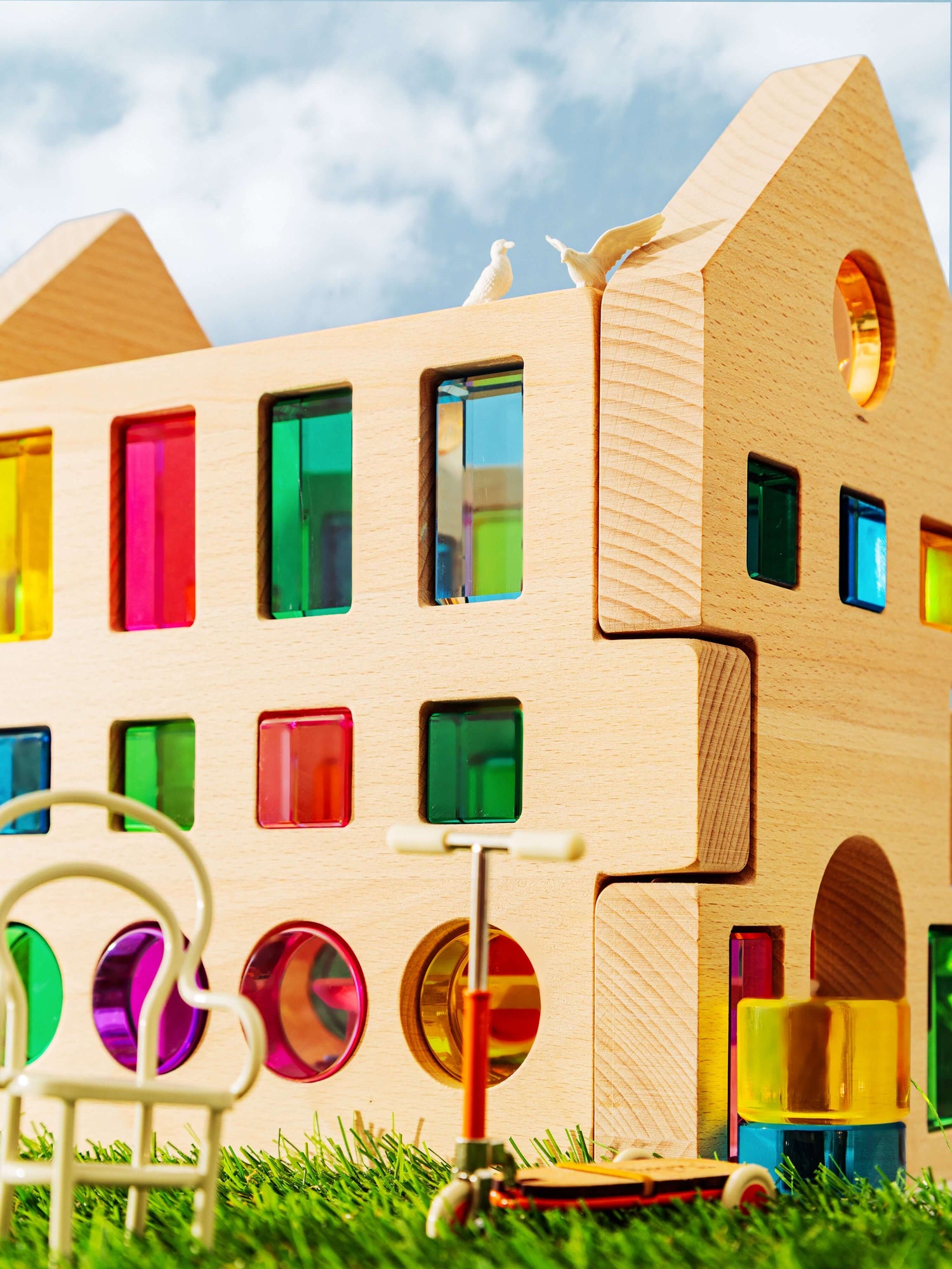 Rêve House Set modular wooden building set with colorful transparent panels, complete with toy scooter and chair.
