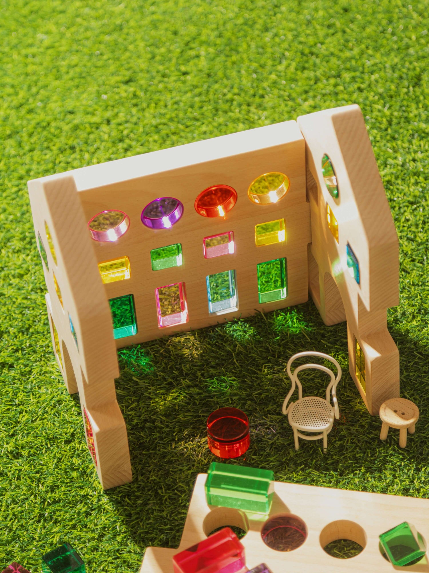 Rêve House Set modular wooden building set with colorful transparent windows and mini furniture on green grass.