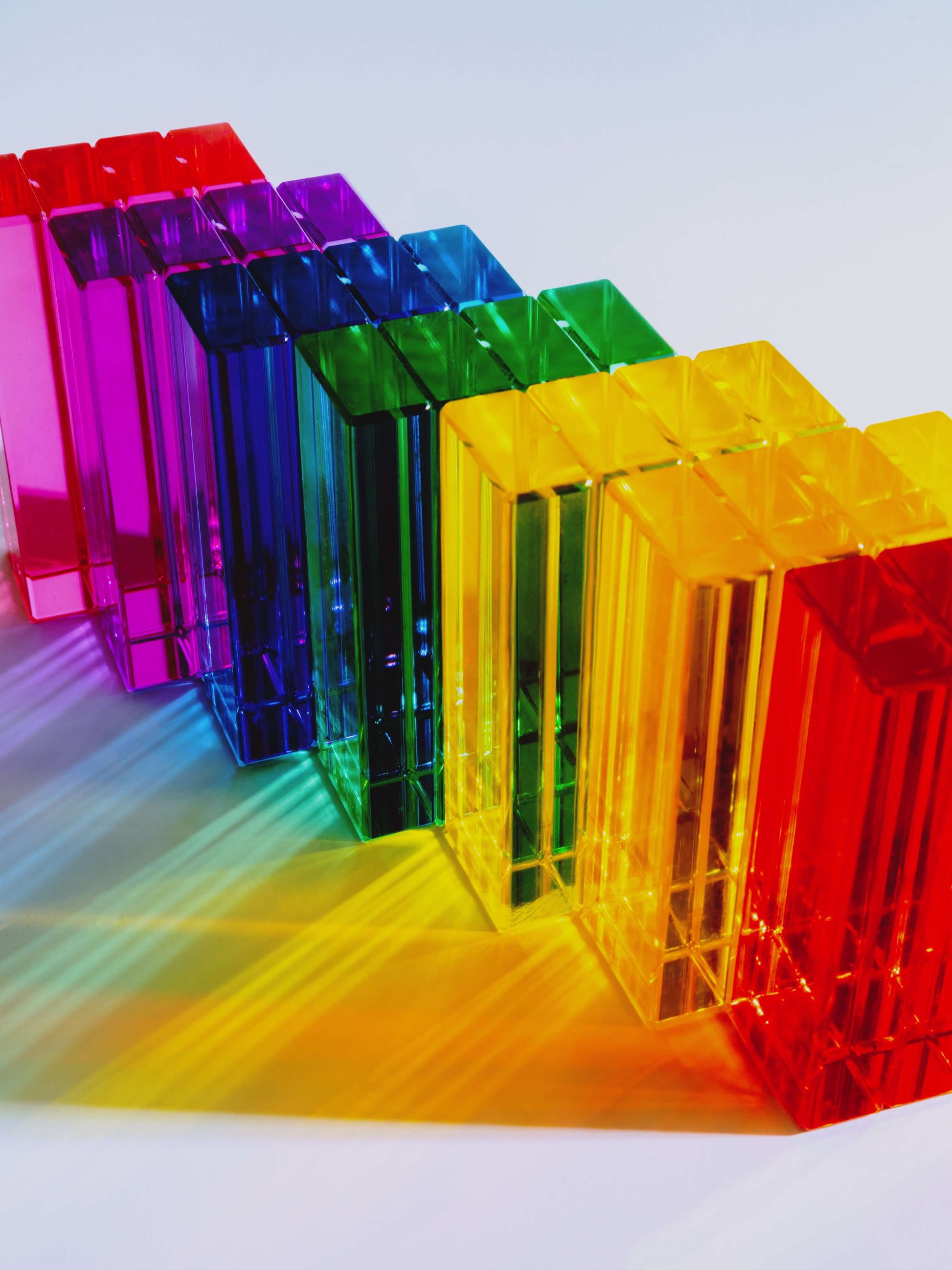 Illume Tower acrylic stacking blocks in a vibrant rainbow arrangement on a light background.