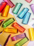 Colorful Illume Tower acrylic stacking blocks arranged with crayons on colored paper.