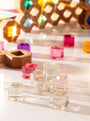 Colorful cosmic cube acrylic glitter blocks arranged on a bright surface, reflecting light and textures.