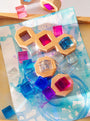 Colorful cosmic cube acrylic glitter blocks on an artistic blue background, enhancing play with light and texture.