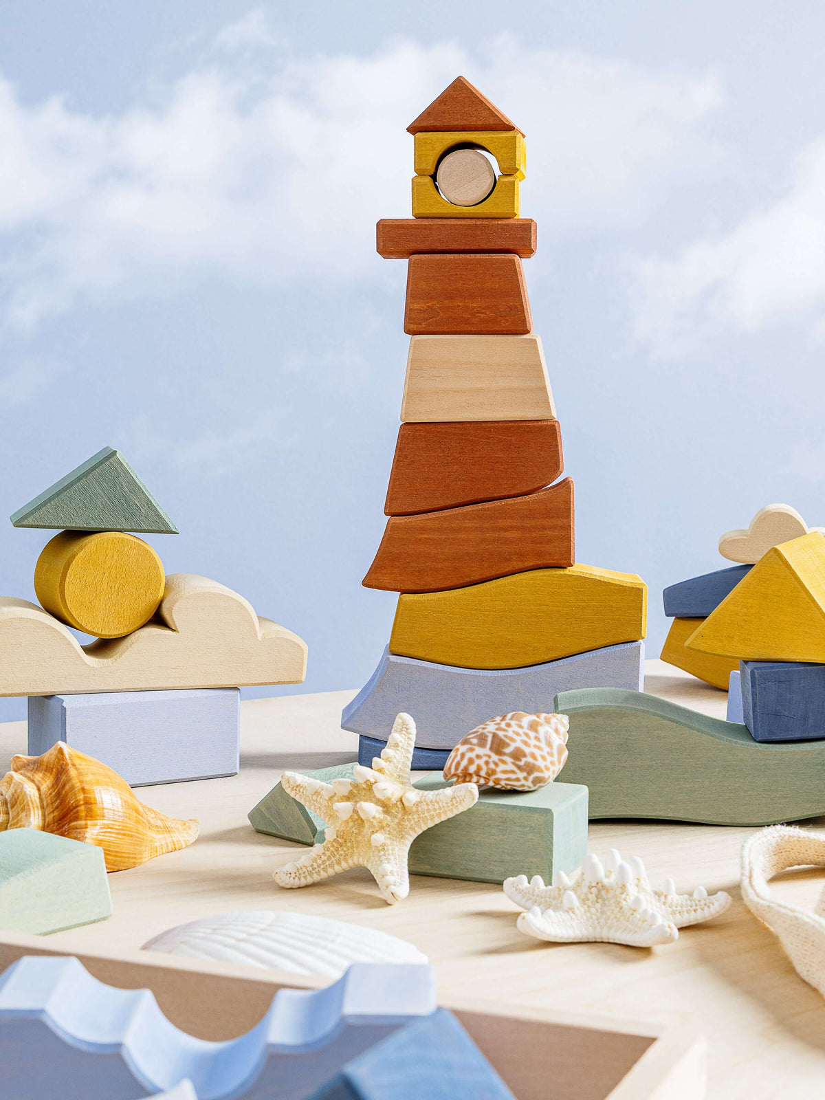 Byron Lighthouse Puzzle displayed with stacked wooden pieces and seashells on a light surface.