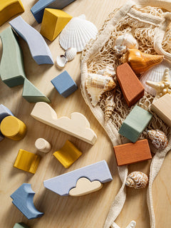 Colorful wooden pieces of the Byron lighthouse Puzzle on a wooden surface, designed for imaginative play.