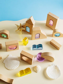 Laguna Block Set featuring natural beechwood and colorful acrylic pieces on a sandy beach background.