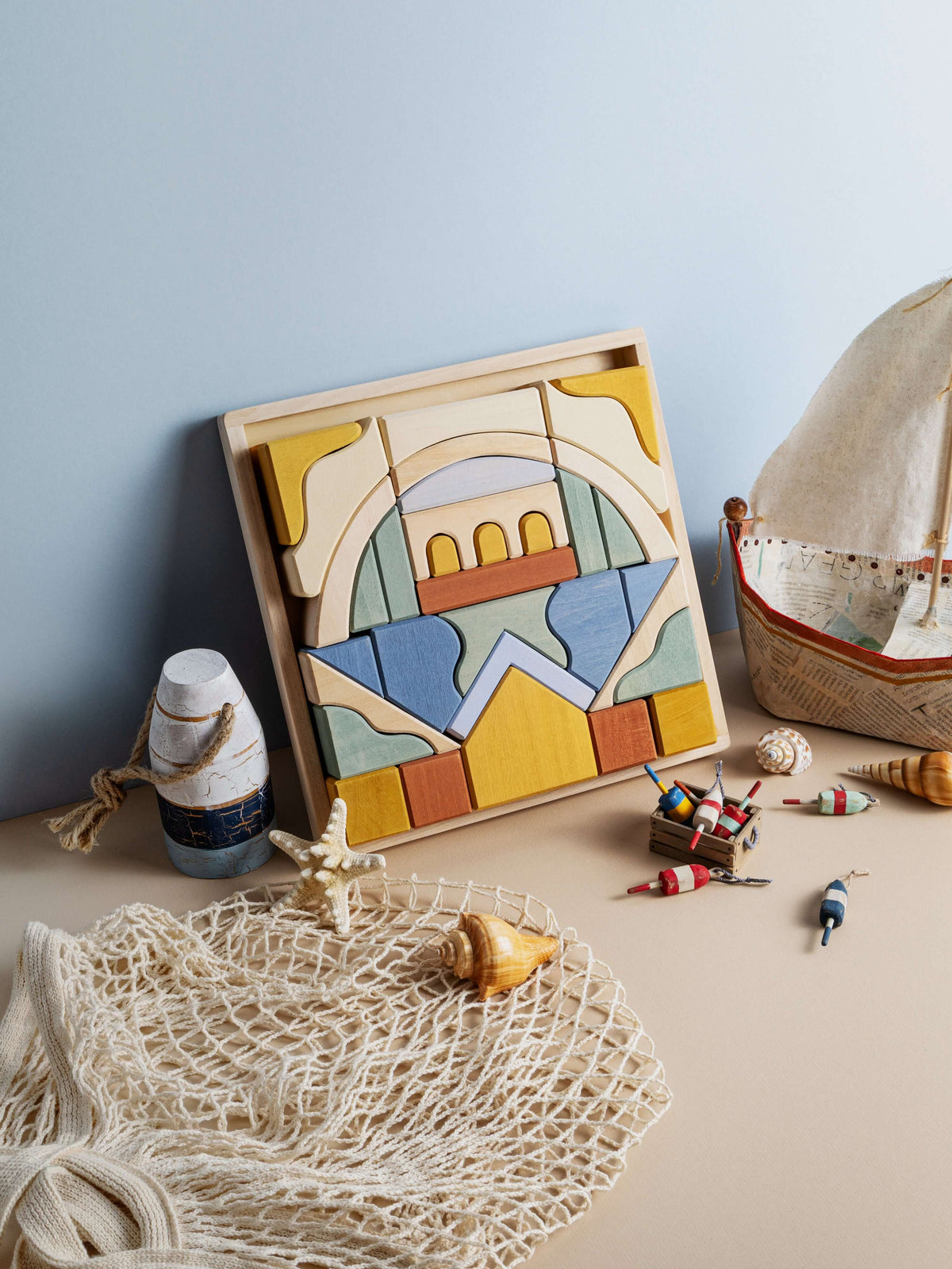 Malibu Puzzle displayed with wooden pieces, seashells, and toy boat, showcasing the California coastline in natural wood.