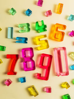 Colorful Number Blocks scattered on a light background, showcasing numbers 1-10 in acrylic design.