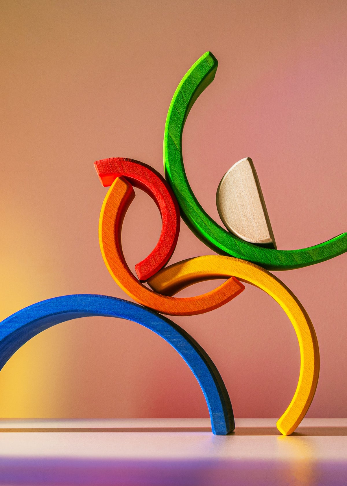 Colorful wooden toy blocks stacked on a gradient background