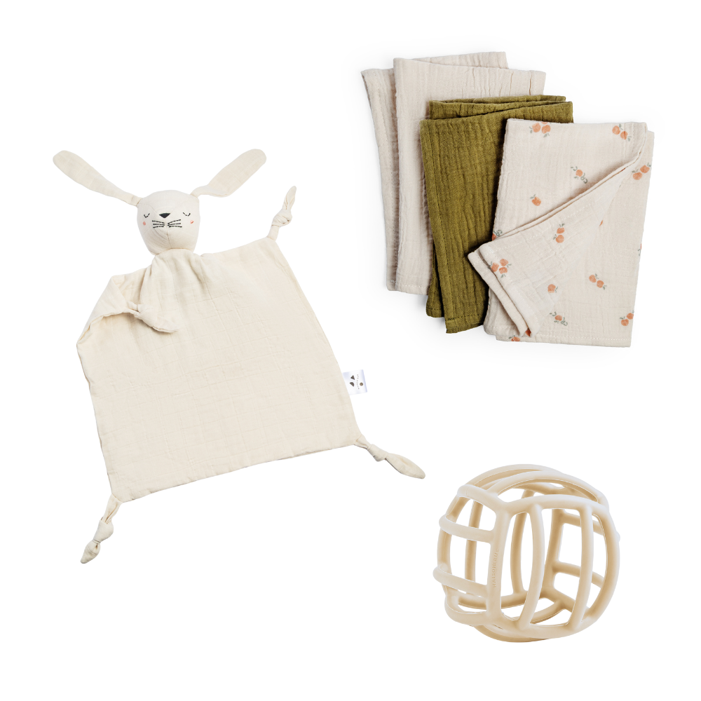 Baby comfort items including a soft toy, blanket, and ball on a white background