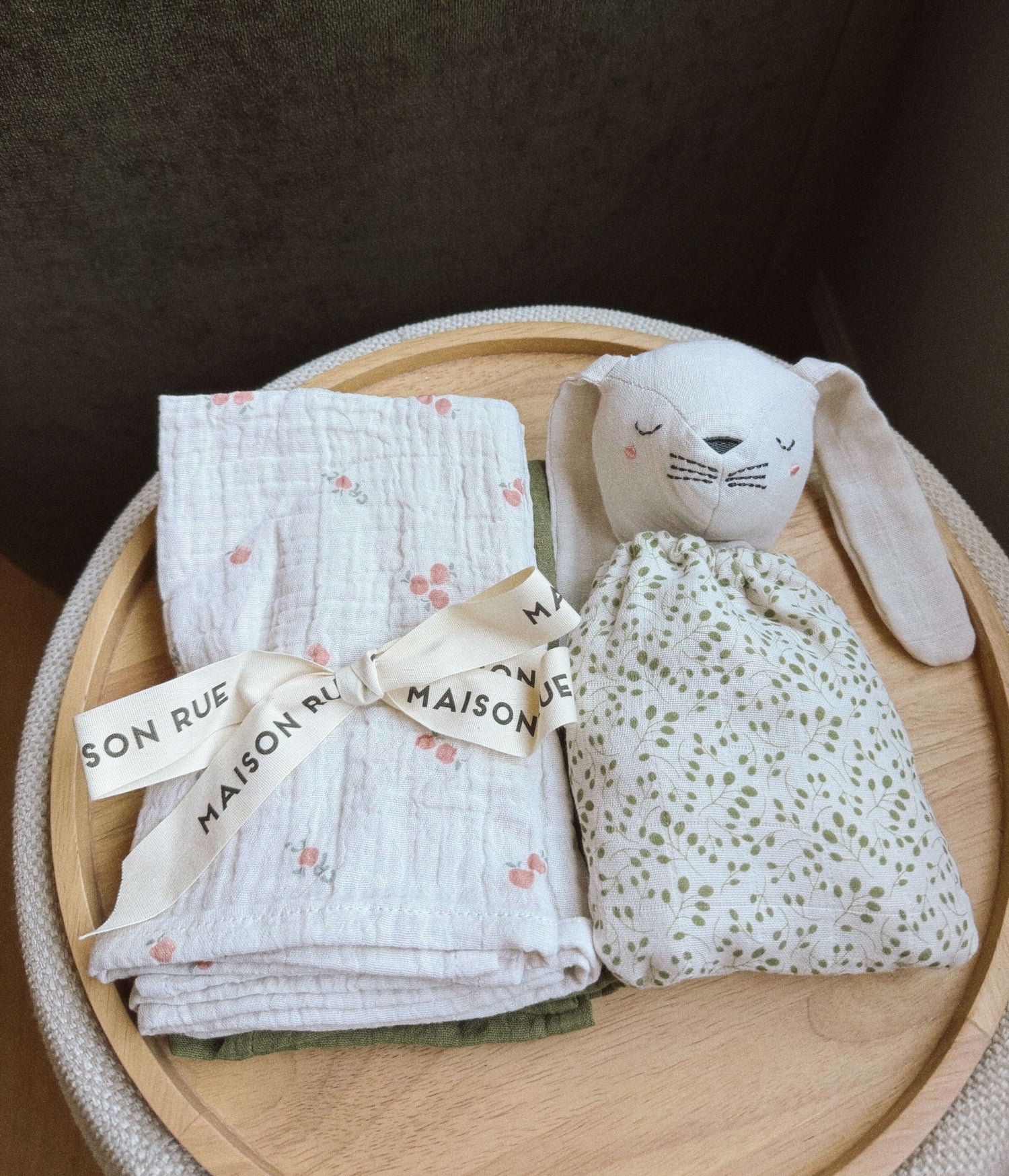 Pocket Pals organic cotton bunny comforter and floral muslin blanket on a round tray.