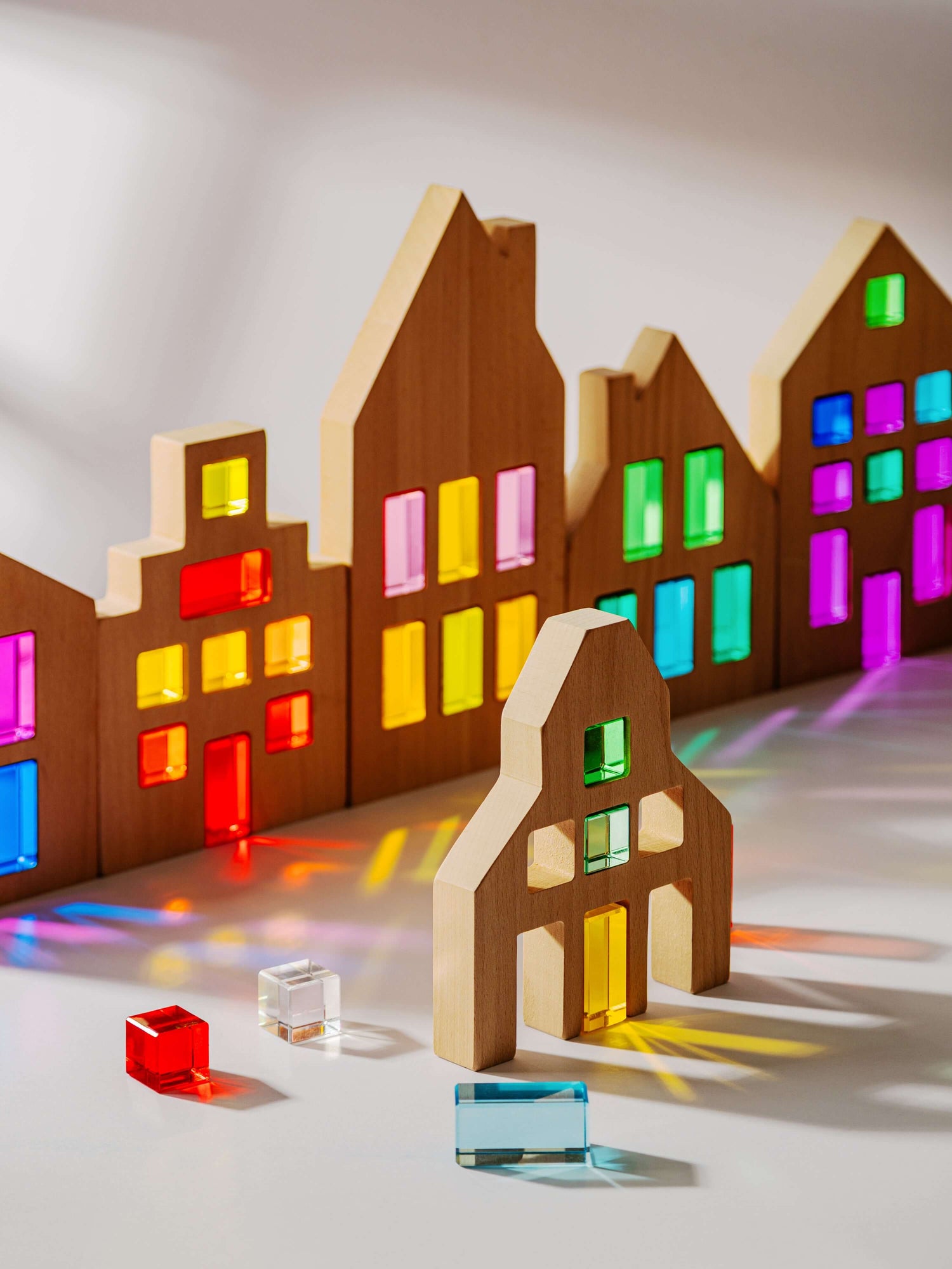 Colorful Canal House Blocks set showcasing translucent acrylic details and wooden houses in various shapes.