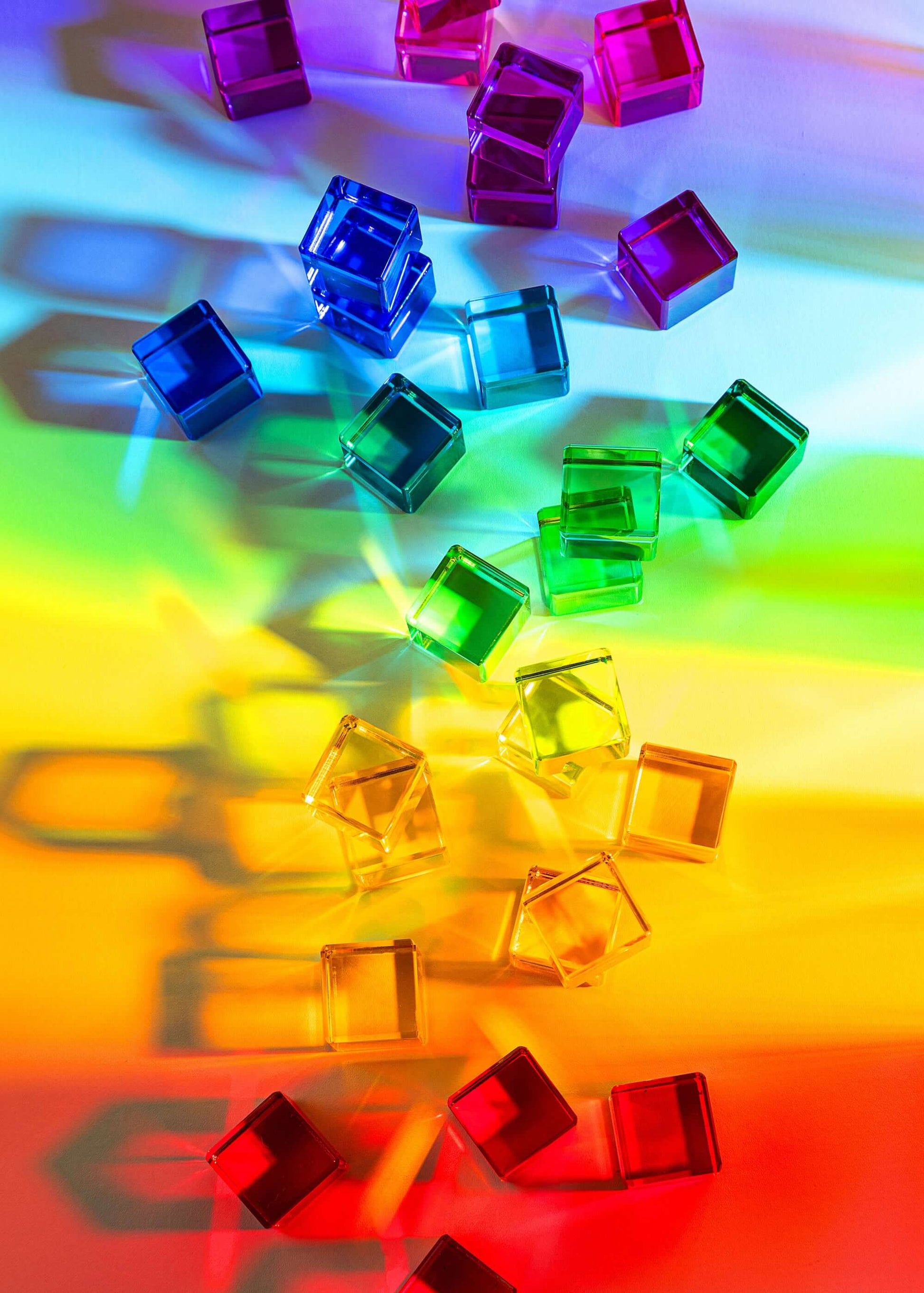 Colorful transparent cubes on a rainbow gradient background