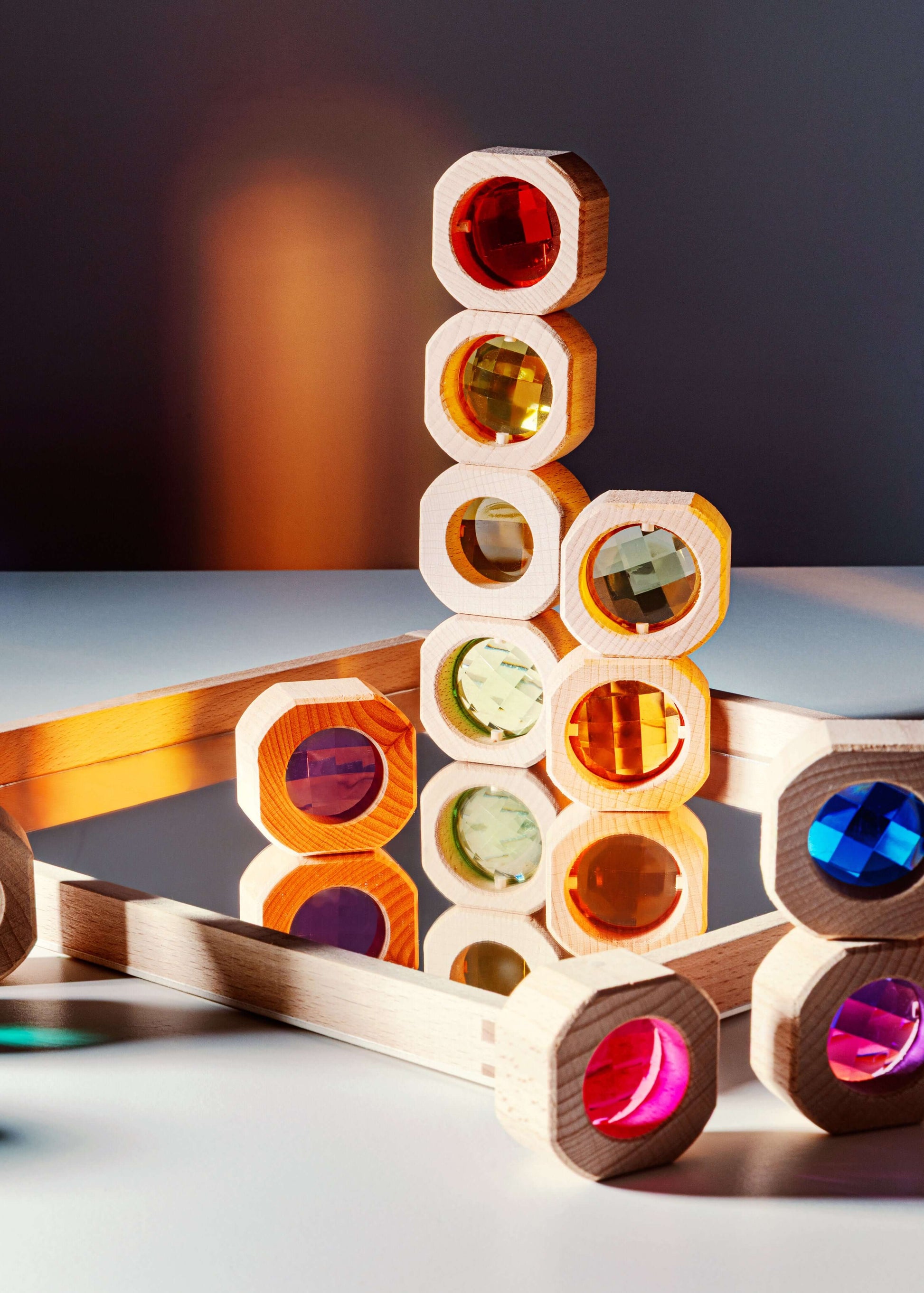 Colorful wooden block puzzle on a reflective surface with a dark background