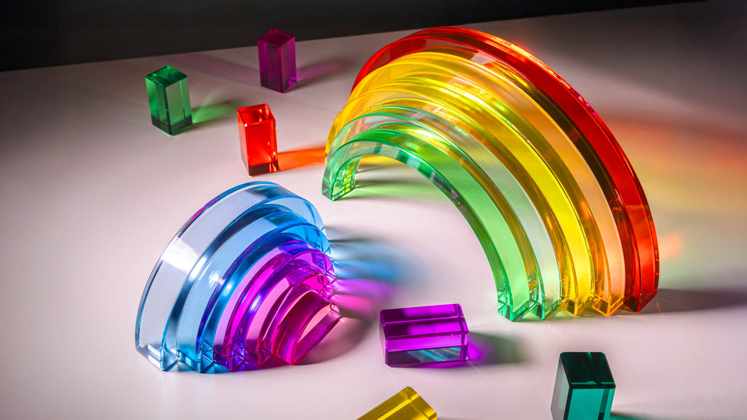 Lucid Rainbow acrylic stacking toy featuring vibrant translucent arches and colorful blocks.