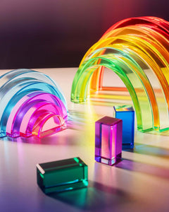 Lucid Rainbow stacking toy with vibrant translucent arches and geometric shapes reflecting light.