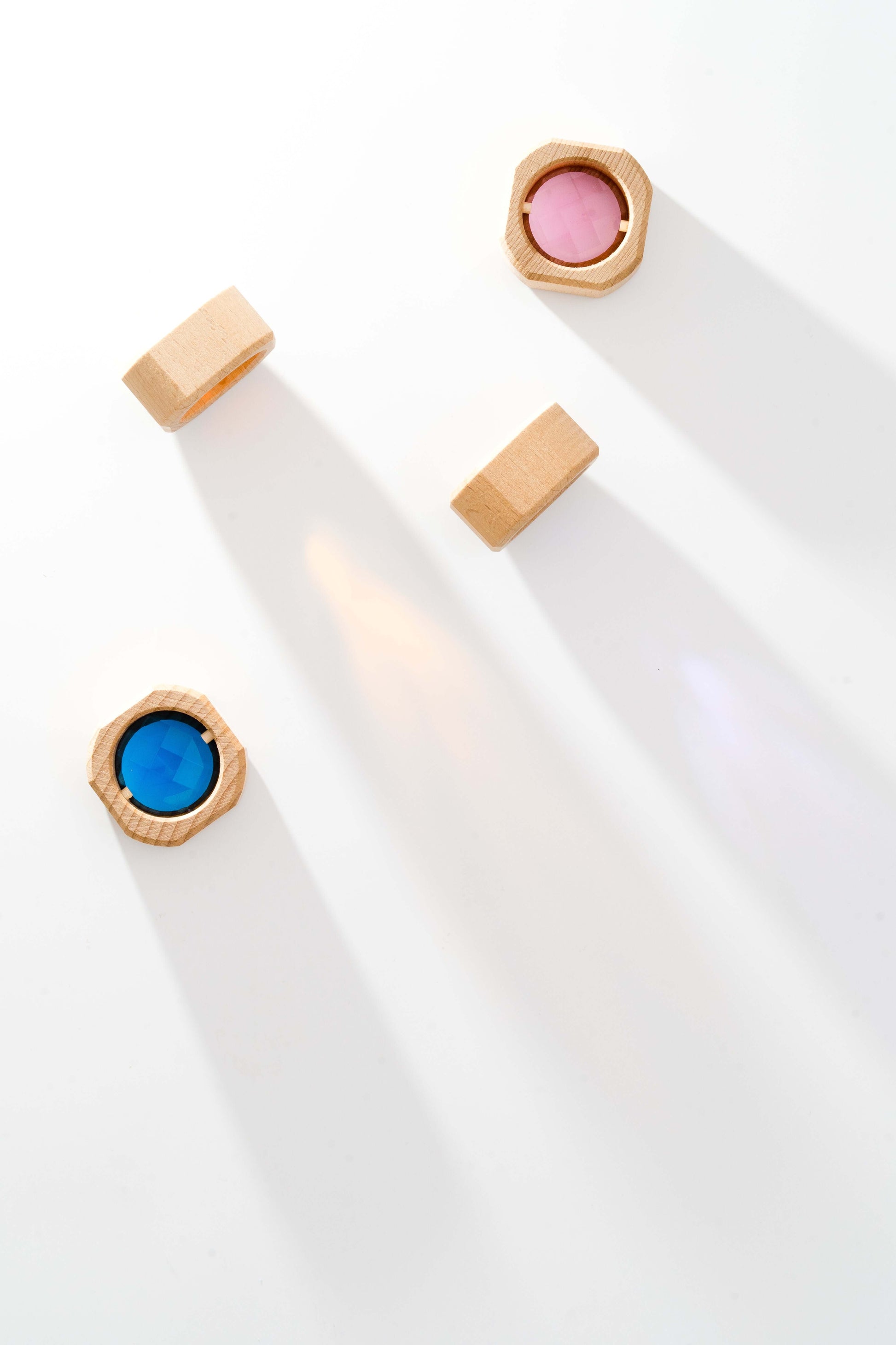 Acrylic rainbow and wooden cubes showing colorful reflections on white background