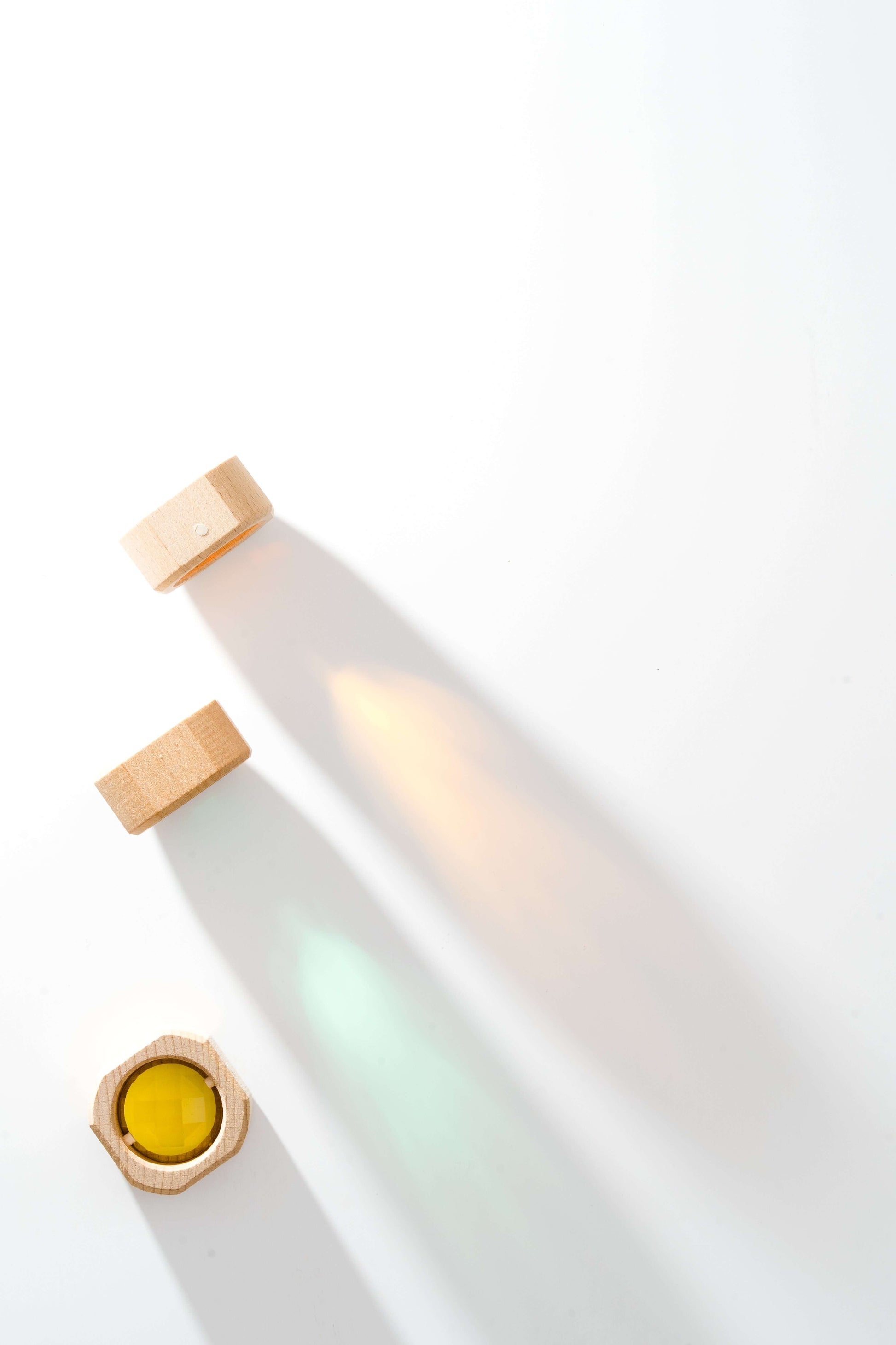 Acrylic rainbow and wooden cubes showing colorful reflections on white background