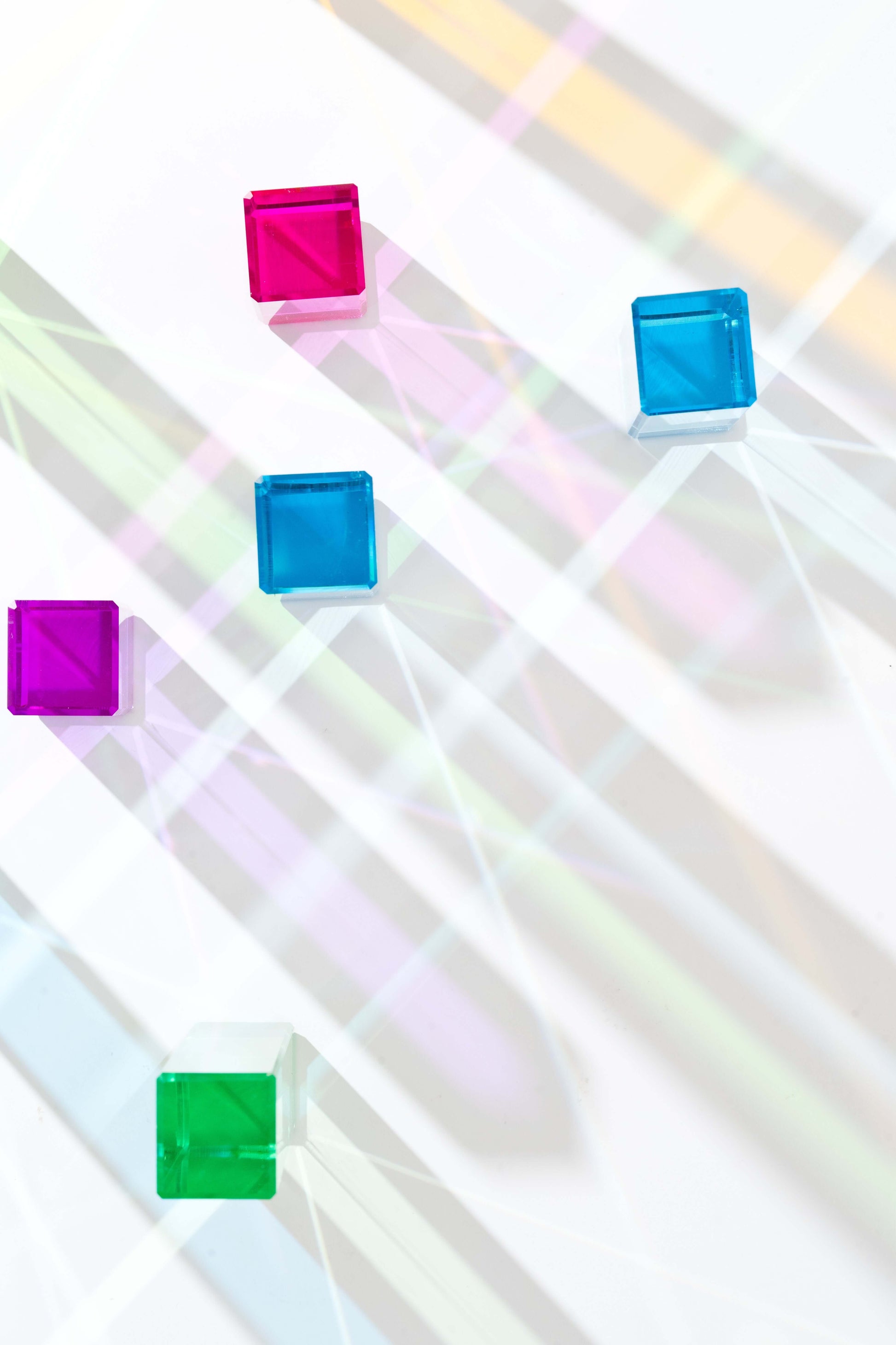 Acrylic rainbow cubes showing colorful reflections on white background