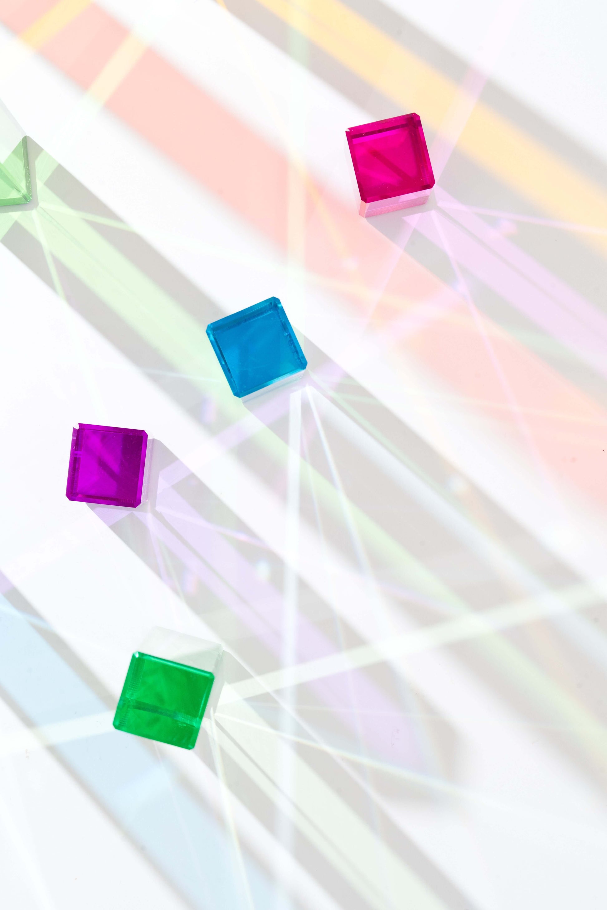 Acrylic rainbow cubes showing colorful reflections on white background