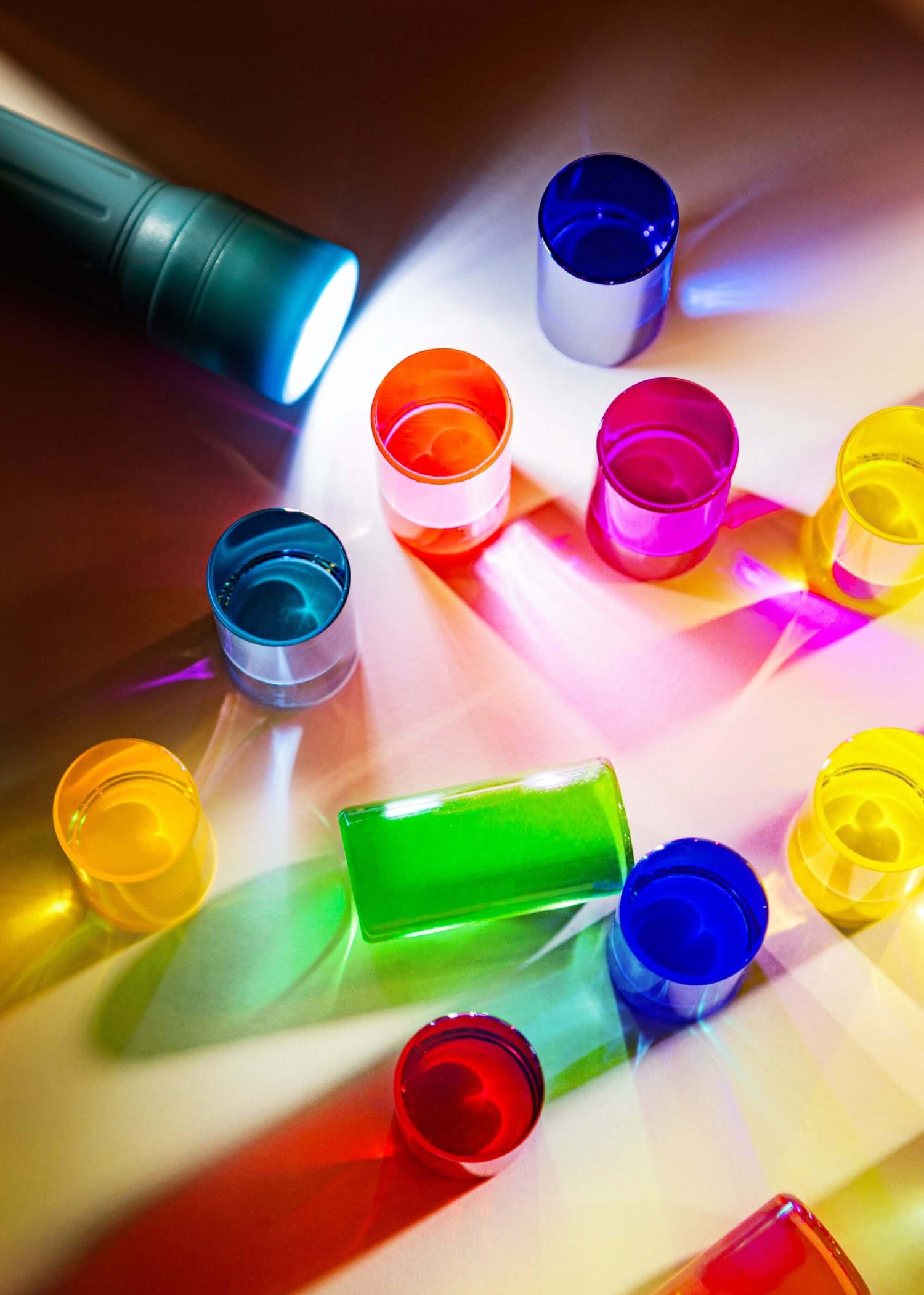 Colorful blocks on a reflective surface with a torch shining light through them