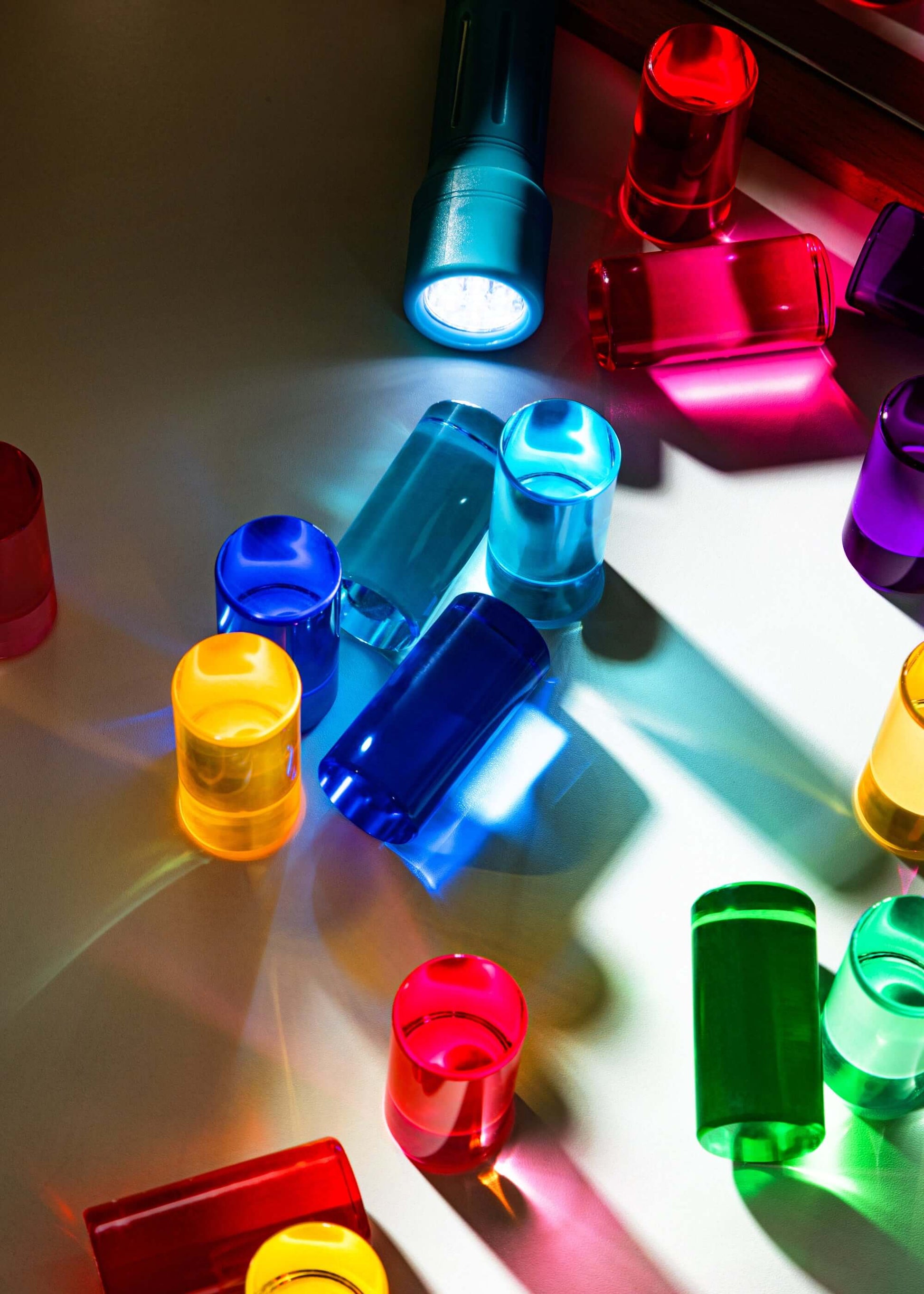 Colorful round blocks on a reflective surface with light reflections.