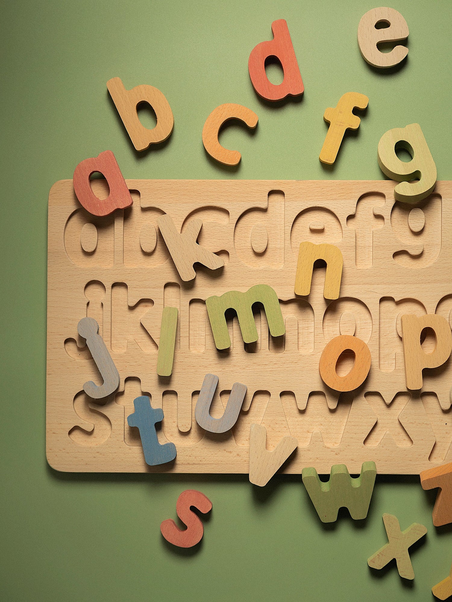Colorful lowercase letters from the lowercase alphabet puzzle on a wooden base, perfect for early literacy development.