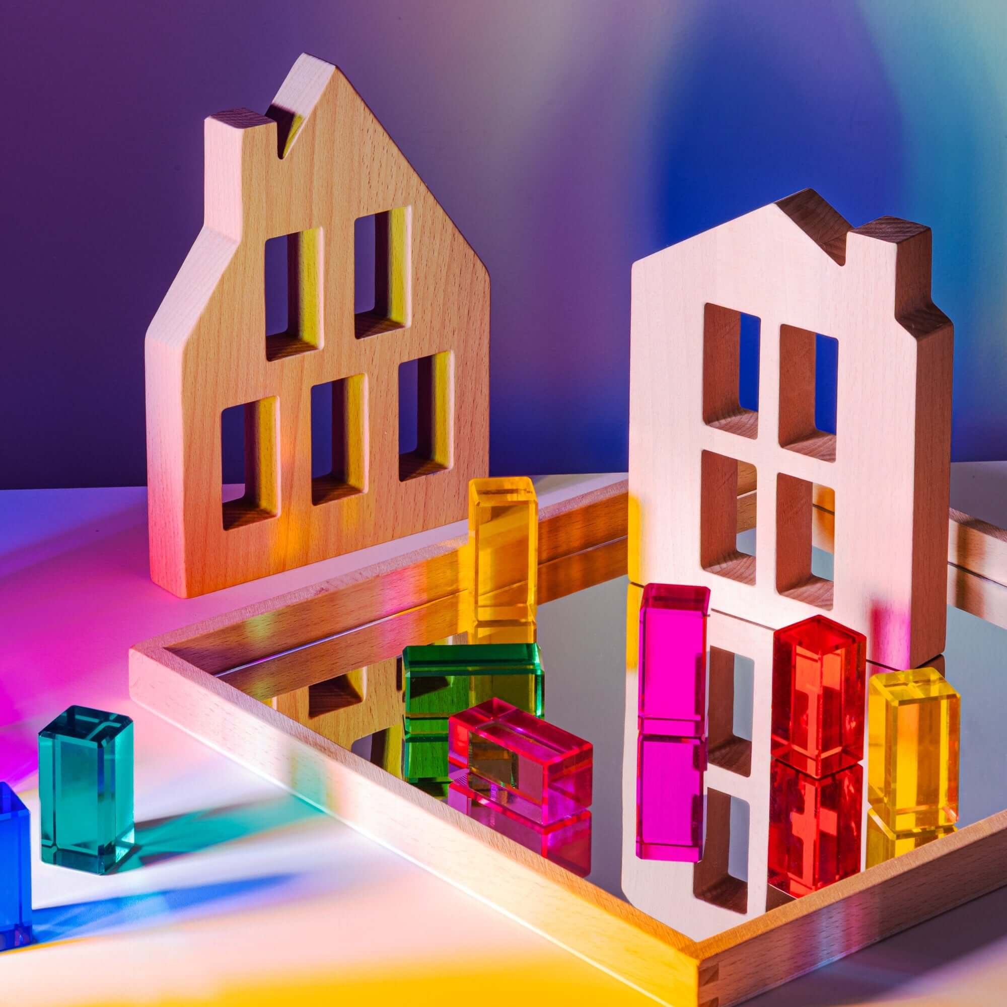 Colorful transparent building blocks with wooden frames on a reflective surface