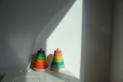 Suki Stacking Tower wooden toddler stacking toy set with colorful rings in pastel and primary colors on table
