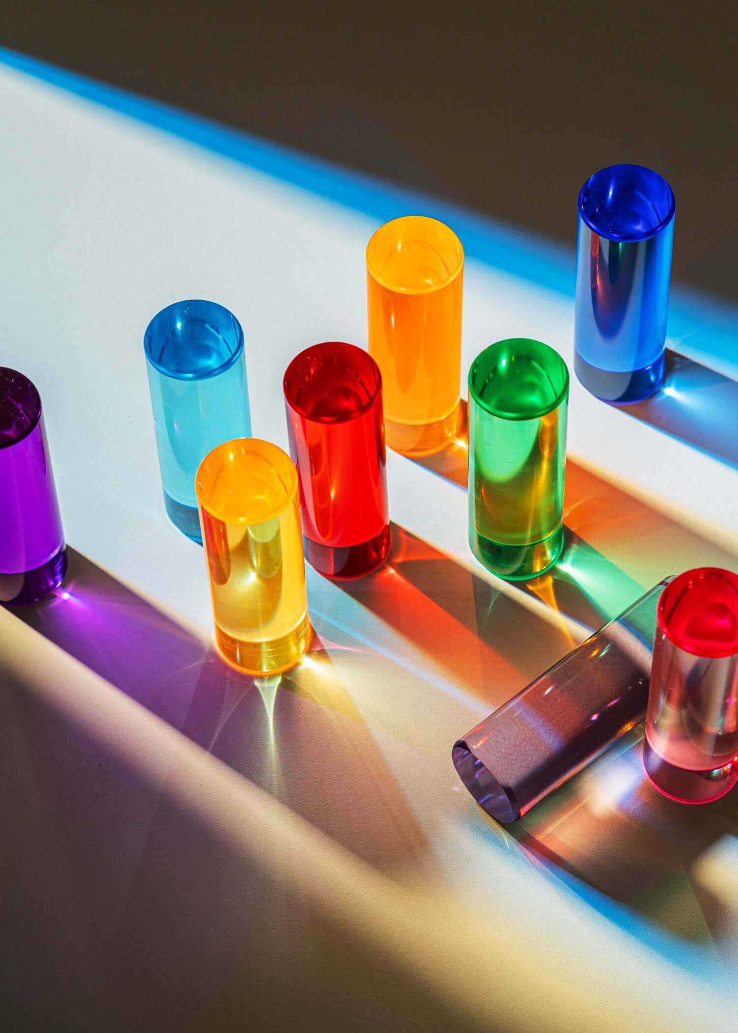 Colorful transparent acrylic blocks on a reflective surface with light reflections