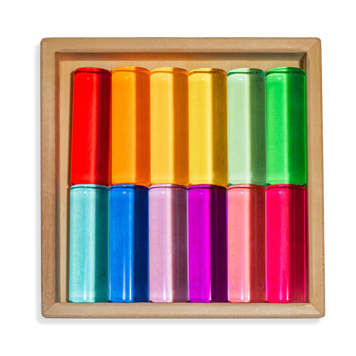 Set of colorful cylindrical objects in a wooden box on a white background